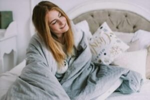 a smiling woman sitting on a bed