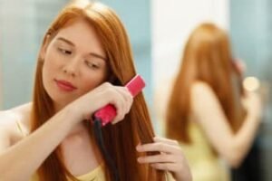 a young girl fixing her tresses