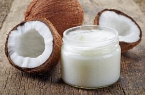 fresh coconuts and coconut oil on wooden table