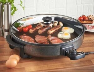 frying eggs, meat, tomatoes, and sausages