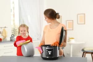 mother and daughter wiping pots