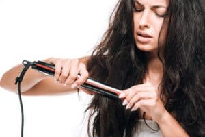 woman-upset-while-using-straightening-iron