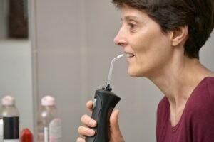 woman using tooth cleaning tool