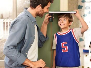 a father measuring the height of his son