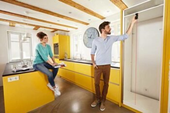 a man measuring the interior height of a cabinet