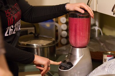A woman adjusts the speed of a kitchen appliance