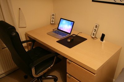 a laptop and a mouse on the brown table