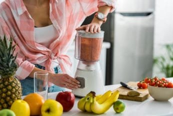 close-up of a woman making a shake at home