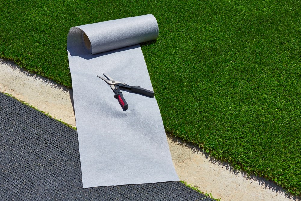 artificial-grass-turf-installation-in-garden-with-tools