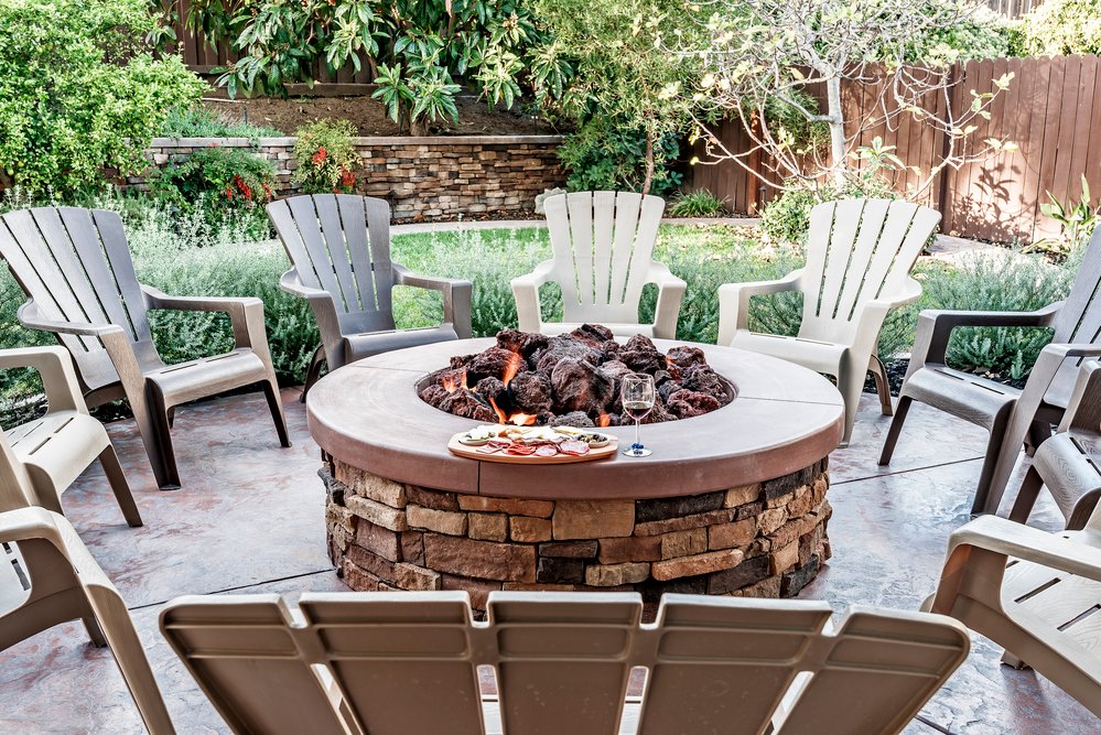 Large circle fireplace sorrounded by wooden chairs