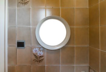 Round frame hanging on a tiled wall