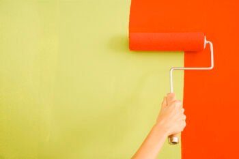 a woman painting a room with orange